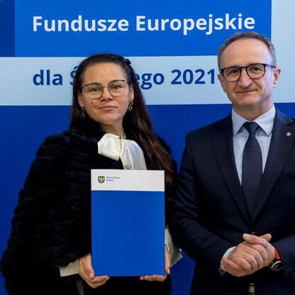 Grzegorz Boski i inny uczestnik spotkania przedstawiają projekty dofinansowane z Europejskich Funduszy dla Śląska 2021. (wygenerowano przez AI)