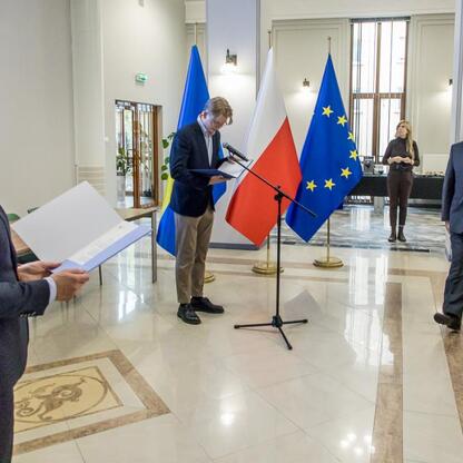 Wicemarszałek Grzegorz Boski i jego zastępca Joanna Bojczuk wręczają listy gratulacyjne przedstawicielom beneficjentów projektów dofinansowanych ze środków europejskich w Urzędzie Marszałkowskim Wojew (wygenerowano przez AI)