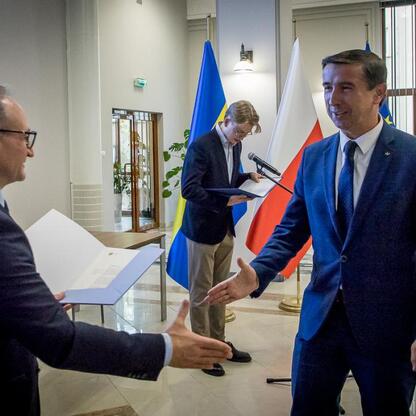 Wicemarszałek Grzegorz Boski i Joanna Bojczuk wręczają listy gratulacyjne wojewódzkiej delegacji projektów dofinansowanych z Europejskich Funduszy Regionalnych. (wygenerowano przez AI)