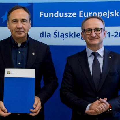 Grzegorz Boski i inny mężczyzna przedstawiają projekt finansowany z Europejskich Funduszy dla Śląska 2021-2027. (wygenerowano przez AI)