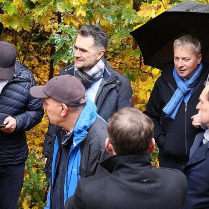 Grupa men prowadzi dyskusję o reaktywacji linii kolejowej Katowice-Jastrzębie, podczas spotkania z wiceministrem infrastruktury Piotrem Malepszakiem. (wygenerowano przez AI)