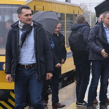 Grupa ludzi na stacji kolejowej w Katowicach, omawiając reaktywację linii do Jastrzębia. (wygenerowano przez AI)