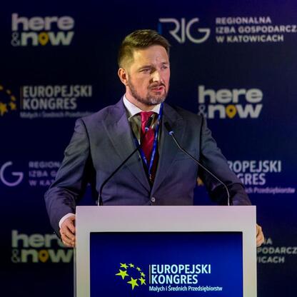 Podczas Europejskiego Kongresu Małych i Średnich Przedsiębiorstw w Katowicach, przedstawiciel Województwa Śląskiego, Leszek Pietraszek, przemawia na podium. (wygenerowano przez AI)