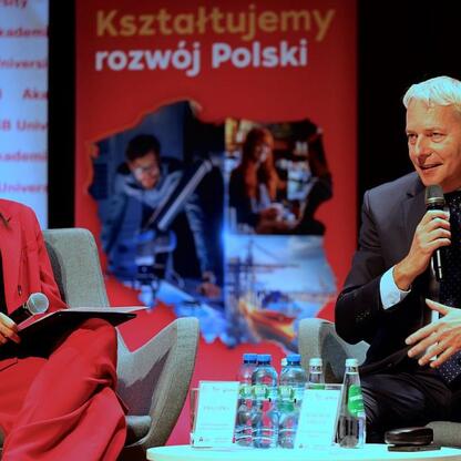 Panel dyskusyjny w Tychach: Marszałek Wojciech Saługa i inny uczestnik omawiają bezpieczeństwo i odporność cywilną i gospodarczą. (wygenerowano przez AI)