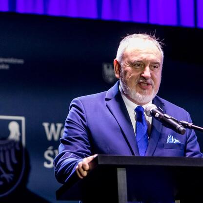 Podczas Forum Sołtysów w Koszęcinie, przedstawiciel Województwa Śląskiego przemawia na podium. (wygenerowano przez AI)