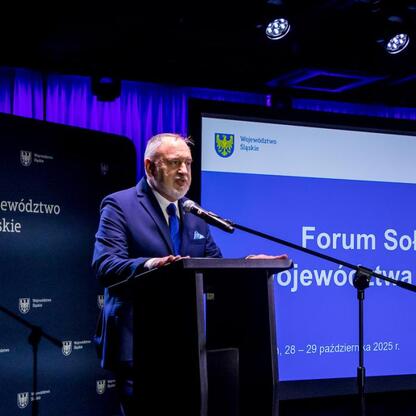 Podczas Forum Sołtysów w Koszęcinie, uczestnik prezentuje wyniki konkursu „Piękna wieś Województwa Śląskiego”. (wygenerowano przez AI)