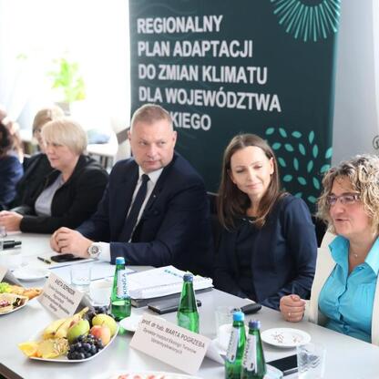 Członek Zarządu Województwa Rafał Adamczyk prowadzi dyskusję o Regionalnym Planie Adaptacji do zmian klimatu dla Śląska. (wygenerowano przez AI)