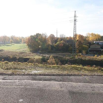 Ruralny krajobraz z drogą i elektroinstalacjami, symbolizujący rozwój infrastruktury w regionie Śląskim. (wygenerowano przez AI)