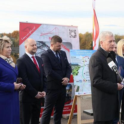Wojciech Saługa, Marszałek Województwa Śląskiego, przemawia na konferencji prasowej o zakończeniu budowy odcinka drogi N-S w Rudzkiej Silesii. (wygenerowano przez AI)