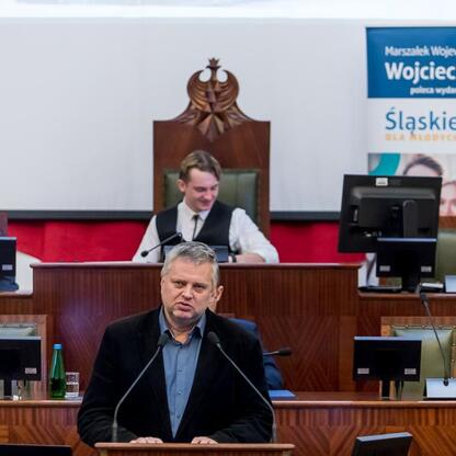 Formalna sesja Młodzieżowego Sejmiku Województwa Śląskiego, gdzie przemawia poseł Piotr Stach, upamiętniając Tragedię Górnośląską. (wygenerowano przez AI)