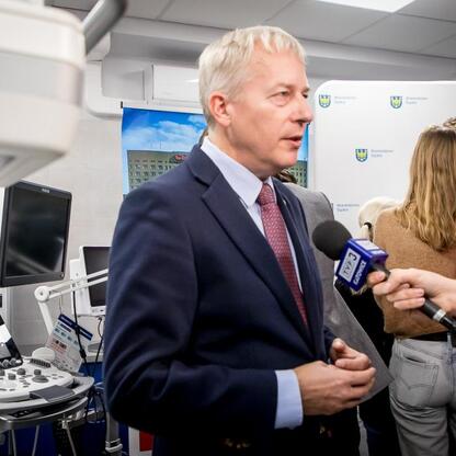 Marszałek Wojciech Saługa przemawia na konferencji prasowej w szpitalu św. Barbary w Sosnowcu, oznaczając nowoczesne inwestycje w medycynę. (wygenerowano przez AI)
