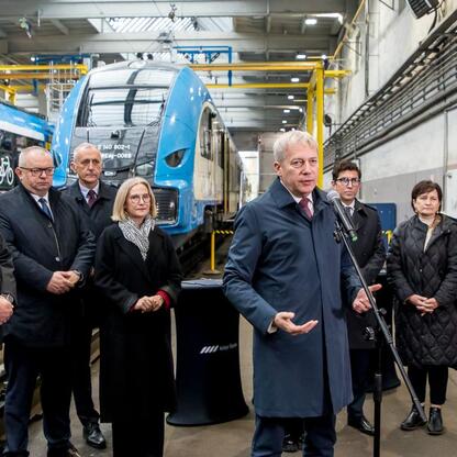 Wicemarszałek Leszek Pietraszek i marszałek Wojciech Saługa wraz z uczestnikami porozumienia o wsparciu dla górników w nowoczesnym zakładzie naprawy pociągów. (wygenerowano przez AI)