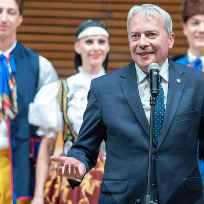 Wojciech Saługa, Marszałek Województwa Śląskiego, przemawia na jubileuszowym koncercie dla seniorów w NOSPR. (wygenerowano przez AI)