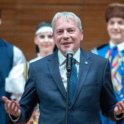 Wojciech Saługa, Marszałek Województwa Śląskiego, przemawia na jubileuszowym koncercie dla seniorów w NOSPR. (wygenerowano przez AI)