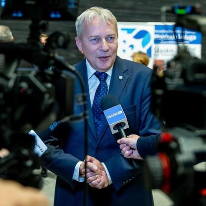 Marszałek Wojciech Saługa w rozmowie z dziennikarzami podczas jubileuszu UTW w Katowicach. (wygenerowano przez AI)