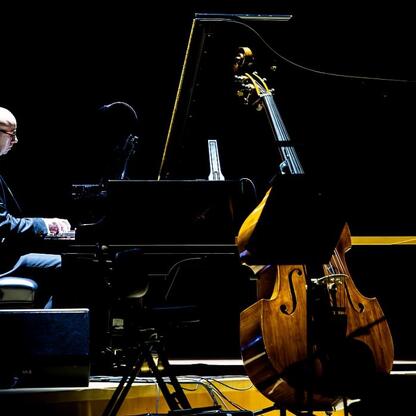 Pianista gra na pianie w oświetlonym sali koncertowej, podkreślając znaczenie seniorów w społeczeństwie. (wygenerowano przez AI)