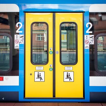 Zdjęcie przedstawia drzwi pociągu Impuls 2, modernizacji floty Silesia. (wygenerowano przez AI)