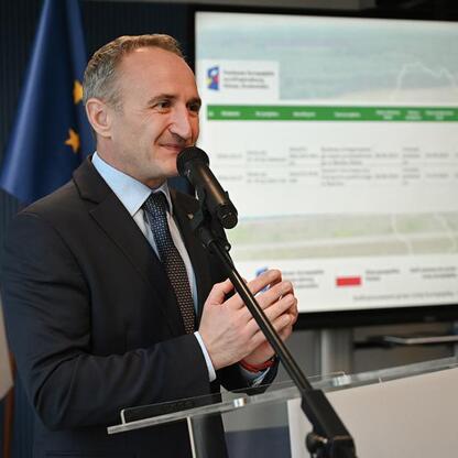 Grzegorz Boski, wicemarszałek województwa śląskiego, przemawia na podium podczas ceremonii podpisania umów na zakup nowych pociągów dla Kolei Śląskich. (wygenerowano przez AI)