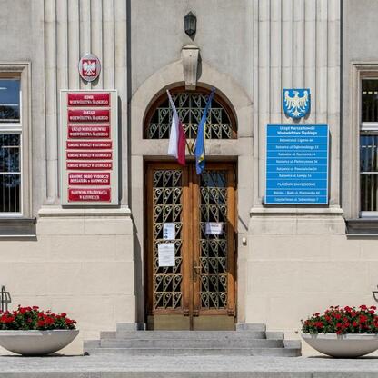 Wejście do Urzędu Marszałkowskiego Województwa Śląskiego w Katowicach, zaznaczające zmianę w godzinach pracy. (wygenerowano przez AI)