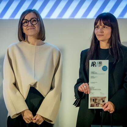 Dwie kobiety otrzymujące certyfikaty na gali w Muzeum Śląskim w Katowicach, nagrodzonej za najlepsze realizacje w konkursie Najlepsza Przestrzeń Publiczna Województwa Śląskiego. (wygenerowano przez AI)