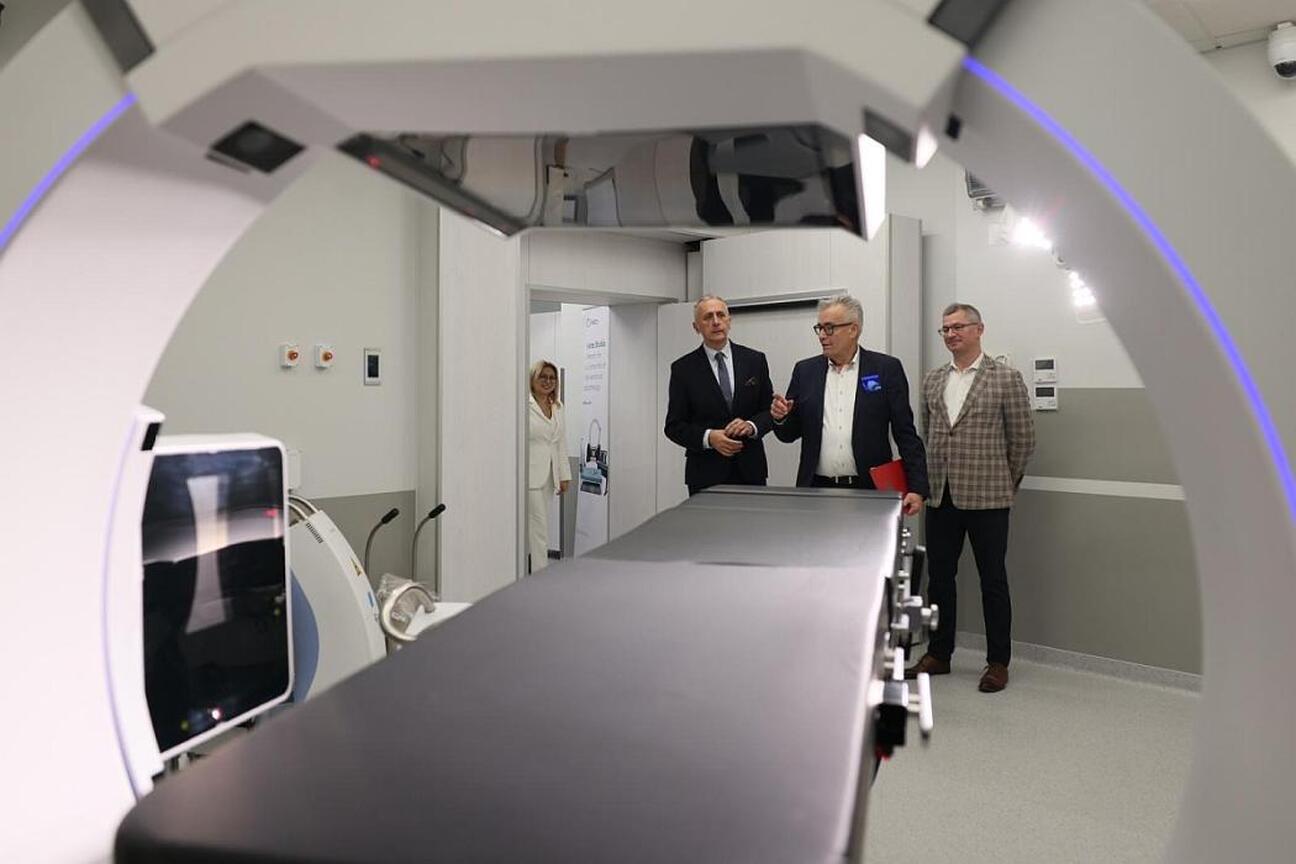 Wicemarszałek Leszek Pietraszek i delegacja na konferencji prasowej o nowoczesnej technologii radioterapii adaptacyjnej w Katowickim Centrum Onkologii. (wygenerowano przez AI)