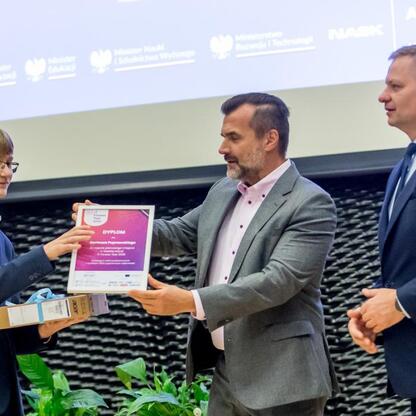 Młody uczeń odbiera nagrodę na konferencji edukacyjnej w Katowicach, wspieranej przez Europejskie Fundusze. (wygenerowano przez AI)