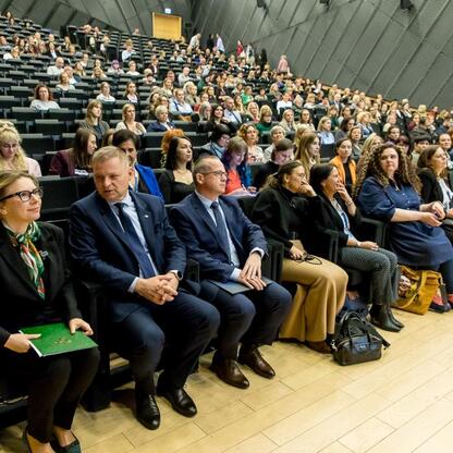 Konferencja o Funduszach Europejskich wspierających edukację w Katowicach, zgromadzeni na Spodku, uczestnicy w formalnym stroju. (wygenerowano przez AI)