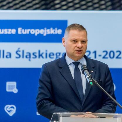 Członek Zarządu Województwa Śląskiego Rafał Adamczyk przemawia na konferencji o Funduszach Europejskich dla Śląska 2021-2027. (wygenerowano przez AI)