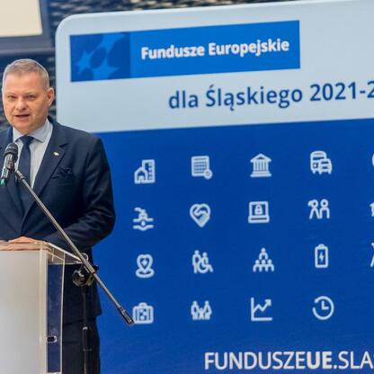 Członek Zarządu Województwa Śląskiego Rafał Adamczyk przemawia na konferencji o Funduszach Europejskich dla Śląska 2021-2027. (wygenerowano przez AI)