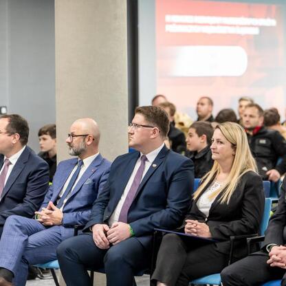 Trzecia edycja Kongresu Rozwojowego Młodzieżowych Drużyn Pożarniczych Województwa Śląskiego w Superauto.pl Stadion Śląski. Uczestnicy w formalnej atmosferze wymieniają doświadczenia i zdobywają nowe u (wygenerowano przez AI)