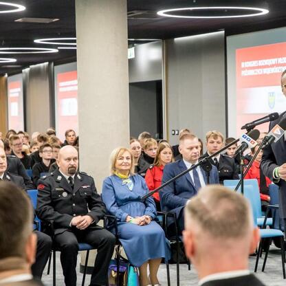 Rafał Adamczyk, członek zarządu województwa, przemawia na Kongresie Rozwojowym Młodzieżowych Drużyn Pożarniczych w Superauto.pl Stadion Śląski. (wygenerowano przez AI)