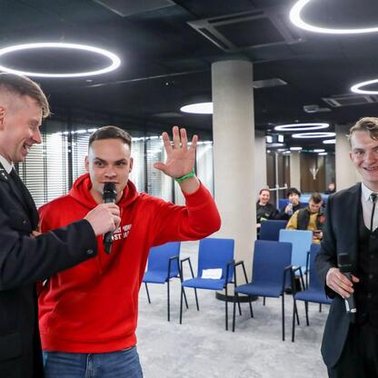 Grupa młodych mężczyzn w formalnym stroju uczestniczy w sesji celebracyjnej na Kongresie Rozwojowym Młodzieżowych Drużyn Pożarniczych Województwa Śląskiego. (wygenerowano przez AI)