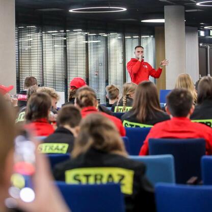 Na Superauto.pl Stadion Śląskiego trwa Kongres Rozwojowy Młodzieżowych Drużyn Pożarniczych, gdzie sekretarz stanu Henryk Kiepura przemawia do uczestników. (wygenerowano przez AI)
