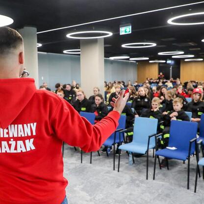 Na zdjęciu przedstawiono trzecią edycję Kongresu Rozwojowego Młodzieżowych Drużyn Pożarniczych Województwa Śląskiego w Superauto.pl Stadion Śląskie. Osoba w czerwonej bluzie 