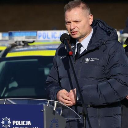 Rafał Adamczyk, Członek Zarządu Województwa Śląskiego, przemawia na uroczystości dostawy 72 nowych radiowozów dla śląskiej policji. (wygenerowano przez AI)