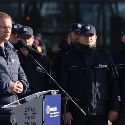 Grupa policjantów w mundurach z napisem 