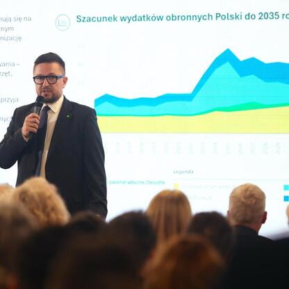 Mężczyzna prezentuje wykres na konferencji o budżecie obronnym Polski do 2035 roku. (wygenerowano przez AI)