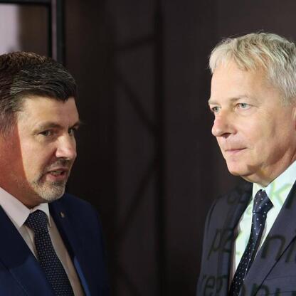 Dwóch mężczyzn w garniturach uczestniczy w spotkaniu dotyczącym potencjału regionu Śląska w sektorze obronnym. (wygenerowano przez AI)