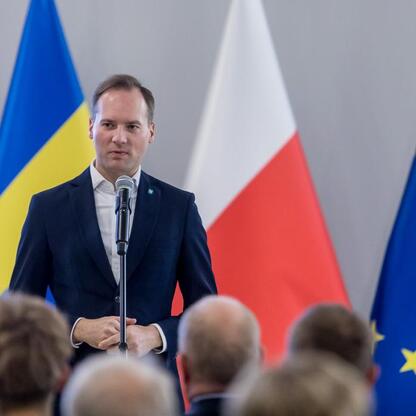 Mężczyzna przemawia na podium podczas ceremonii wręczenia nagród w Pucharze Marszałka Województwa Śląskiego. (wygenerowano przez AI)