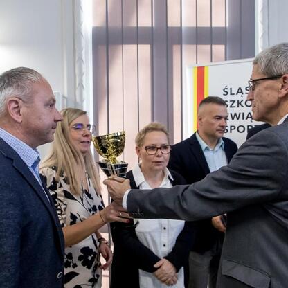 W Urzędzie Marszałkowskim radni Sejmiku Województwa Śląskiego wręczają nagrody zwycięzcom konkursu sportowego. (wygenerowano przez AI)