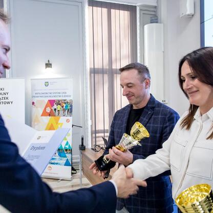 W Urzędzie Marszałkowskim przedstawiciele Sejmiku Województwa Śląskiego wręczają nagrody zwycięzcom Silesia Schools Sports Competition. (wygenerowano przez AI)