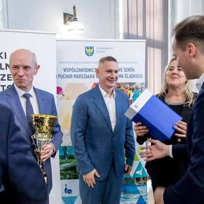 Zdjęcie przedstawia uroczystość w Urzędzie Marszałkowskim Śląskiego, gdzie zwycięzcy Silesian Schools Sports Association Cup otrzymują nagrody. (wygenerowano przez AI)
