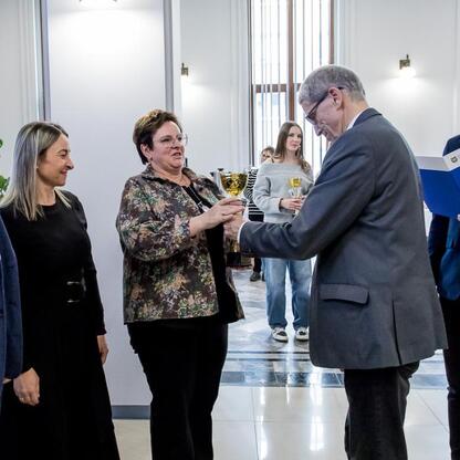 Grupa ludzi w strojach formalnych odbiera nagrody i certyfikaty na ceremonii wręczenia trofeów w Urzędzie Marszałkowskim w Śląskim. (wygenerowano przez AI)