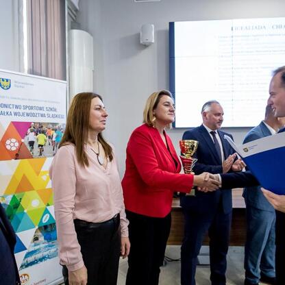 Grupa ludzi w strojach formalnych uczestniczy w ceremonii wręczenia nagród w Urzędzie Marszałkowskim Województwa Śląskiego. (wygenerowano przez AI)