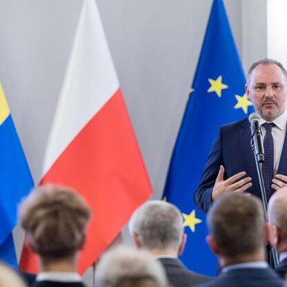 Formalna uroczystość w Urzędzie Marszałkowskim, gdzie przedstawiciel zwycięskich szkół odbiera nagrody za sukcesy sportowe. (wygenerowano przez AI)