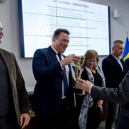 Zwycięzcy sportowego turnieju o Puchar Marszałka Województwa Śląskiego otrzymują nagrody w Urzędzie Marszałkowskim. (wygenerowano przez AI)
