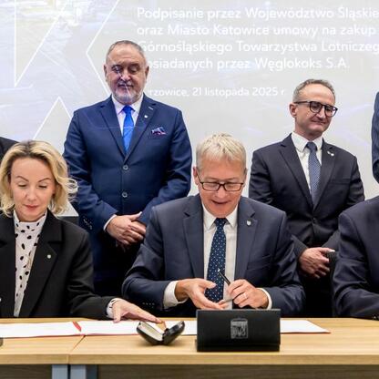 Wojciech Saługa, Leszek Pietraszek i Grzegorz Boski podpisują umowę o przejęciu akcji Górnośląskiego Towarzystwa Lotniczego. (wygenerowano przez AI)
