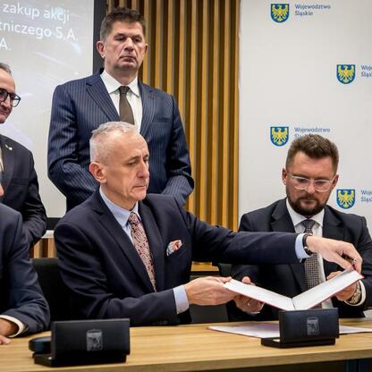 Wojciech Saługa, Leszek Pietraszek i Grzegorz Boski podpisują umowę o przejęciu kontrolnej większości w Katowice Airport. (wygenerowano przez AI)