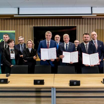 Wojciech Saługa, Leszek Pietraszek i Grzegorz Boski podpisują umowę w Katowicach, dotyczącą przejęcia kontrolnej części akcji GTL przez Województwo Śląskie i miasto Katowice. (wygenerowano przez AI)