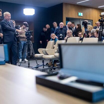 Wojciech Saługa, Marszałek Województwa Śląskiego, prowadzi formalne spotkanie w konferencyjnym pomieszczeniu, gdzie omawiają przejęcie kontrolnej większości w Katowice Airport przez Silesia. (wygenerowano przez AI)